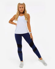 womens gymwear set. White vest top over navy blue and black leggings all made from sustainable recycled plastic fabric