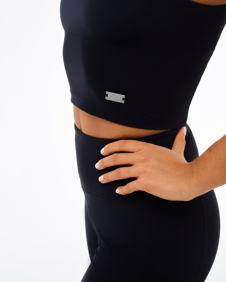 black activewear set including  a crop top with a metal wave detail and leggings made from recycled plastic