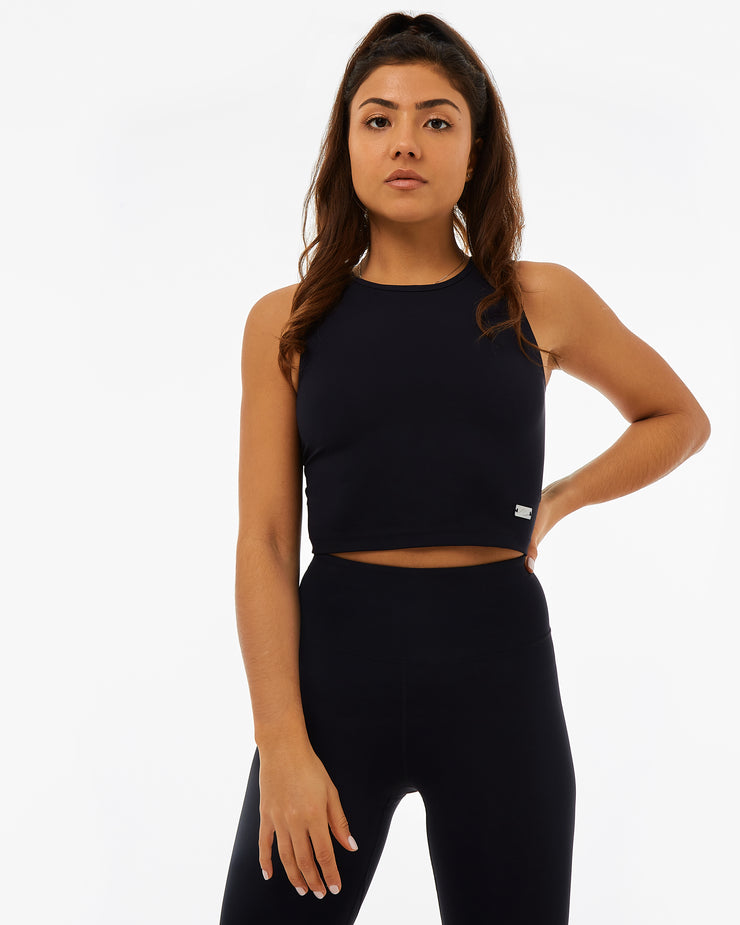 woman in black activewear set wearing a crop top and leggings made from recycled plastic