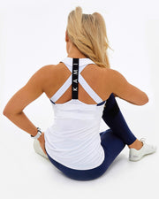 back of white sustainable womens gym top. black band with KAMI branding worn over white crossover sports bra. All made from recycled plastic